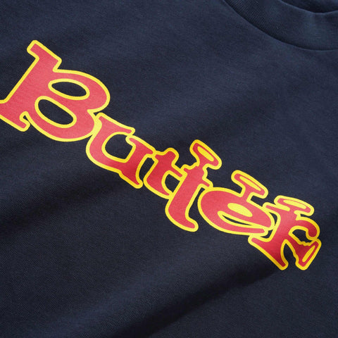 Close-up of a navy t-shirt with the word "Butter" printed in red with a yellow outline across the chest.