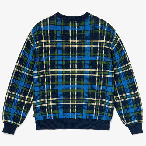 Back view of a navy, blue, green, and cream plaid knit crew-neck sweater laid flat on a white background.