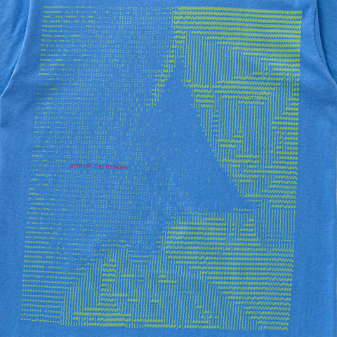Blue t-shirt printed with a large ASCII-style portrait of a face in lime green characters, with small pink text reading "Built for the Tenderness" on the left.