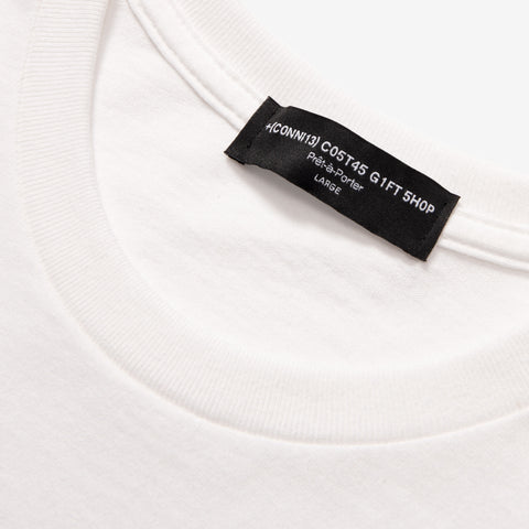 Close-up of the inside neckline of a white t-shirt showing a black woven label reading 'ICONNI13 COSTA5 GIFT SHOP', 'Prêt-à-Porter', 'LARGE'.