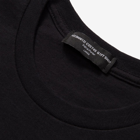 Close-up of a black crew-neck t-shirt collar with a black woven neck label reading "COMME des GARCONS GIFT SHOP", "Pret-a-Porter", and "LARGE".