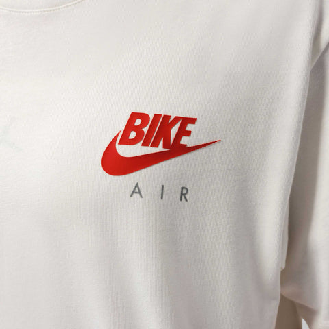Close-up of a white t-shirt with a red swoosh logo above the word BIKE and the letters AIR printed in grey below.