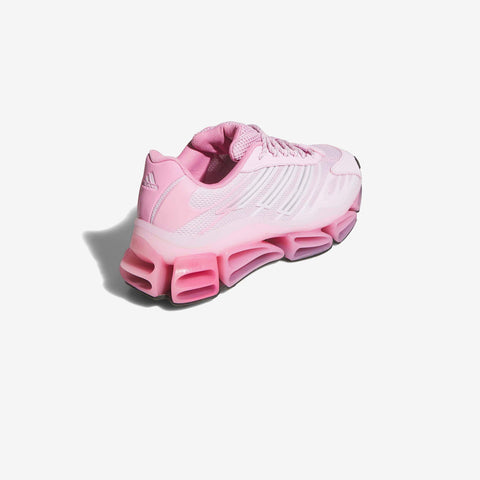 Pink athletic sneaker shown from the rear three-quarter angle, with a pale pink mesh upper and a bold pink segmented sole