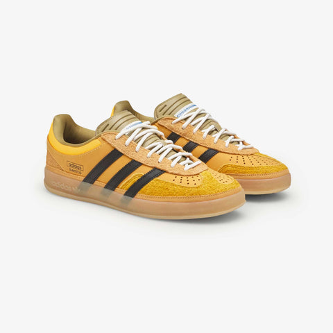 Pair of yellow and orange low-top sneakers with black three-stripe side panels, white laces, and a gum rubber sole.