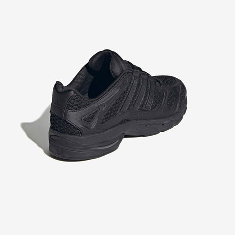 Black athletic running shoe viewed from the rear three-quarter angle, with mesh and synthetic overlays and a chunky sole.