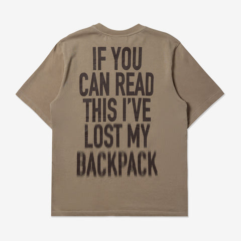 Back of a taupe short-sleeved t-shirt with dark blurred block text reading: IF YOU CAN READ THIS I'VE LOST MY BACKPACK
