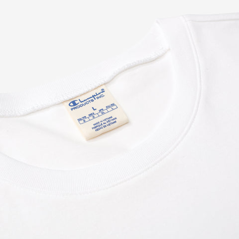 Close-up of the inside neckline of a white t-shirt showing a cream woven label with blue Champion Products Inc. text and size L.