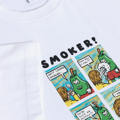 White t-shirt printed with a four-panel comic titled SMOKER! showing a green pickle character smoking and blowing smoke, with the caption "HEY!! I STOPPED SMOKING...