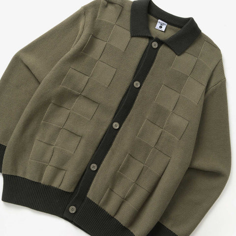 Olive green knit cardigan with a dark collar, dark trim and buttons, and a woven checkerboard texture across the front.
