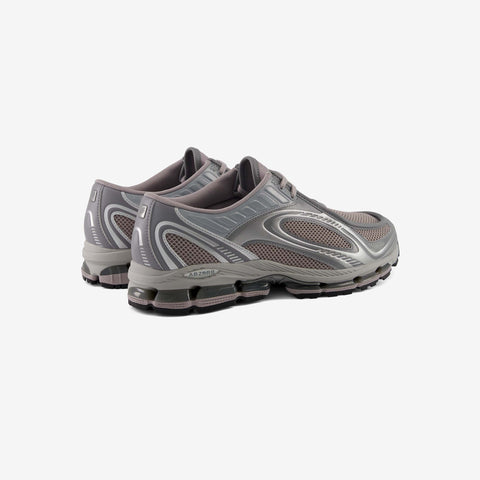 Pair of grey and mauve running shoes with mesh panels, silver overlays and cushioned sole units, shown from the rear three-quarter angle.