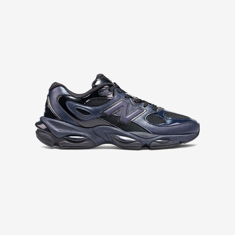 Dark navy and black running sneaker in profile, with mesh and glossy panels, a chunky sole, and a grey N logo on the side.