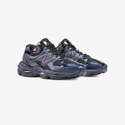 Pair of dark navy and black chunky running sneakers with glossy navy overlays, a black lace-up collar and a purple-grey N logo on the side.