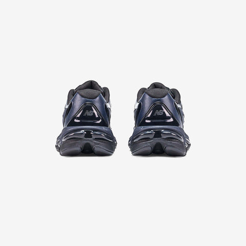 Rear view of a pair of navy blue athletic running shoes with black sculpted midsoles and grey logo accents on the heel.