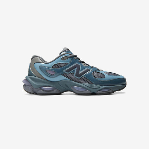 Side view of a teal and grey running sneaker with mesh panels, a large N logo on the side, and chunky lavender midsole cushioning.