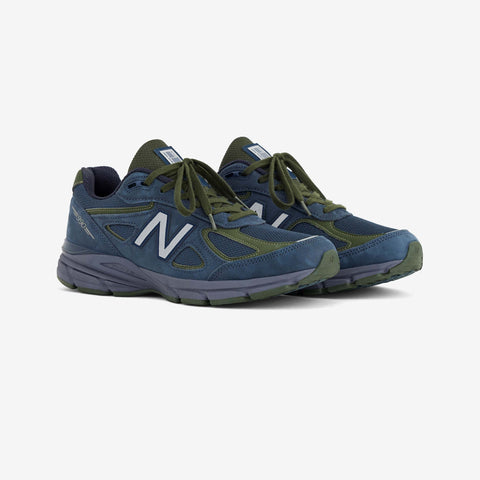 Pair of navy blue and olive green running shoes with silver N logo on the side, shown from the front three-quarter angle.