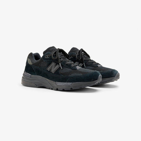 Pair of black suede and mesh athletic sneakers with a chunky sole and a grey N logo on the side.