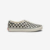 Black and white checkerboard slip-on sneaker with a white rubber sole, shown from the side on a white background.